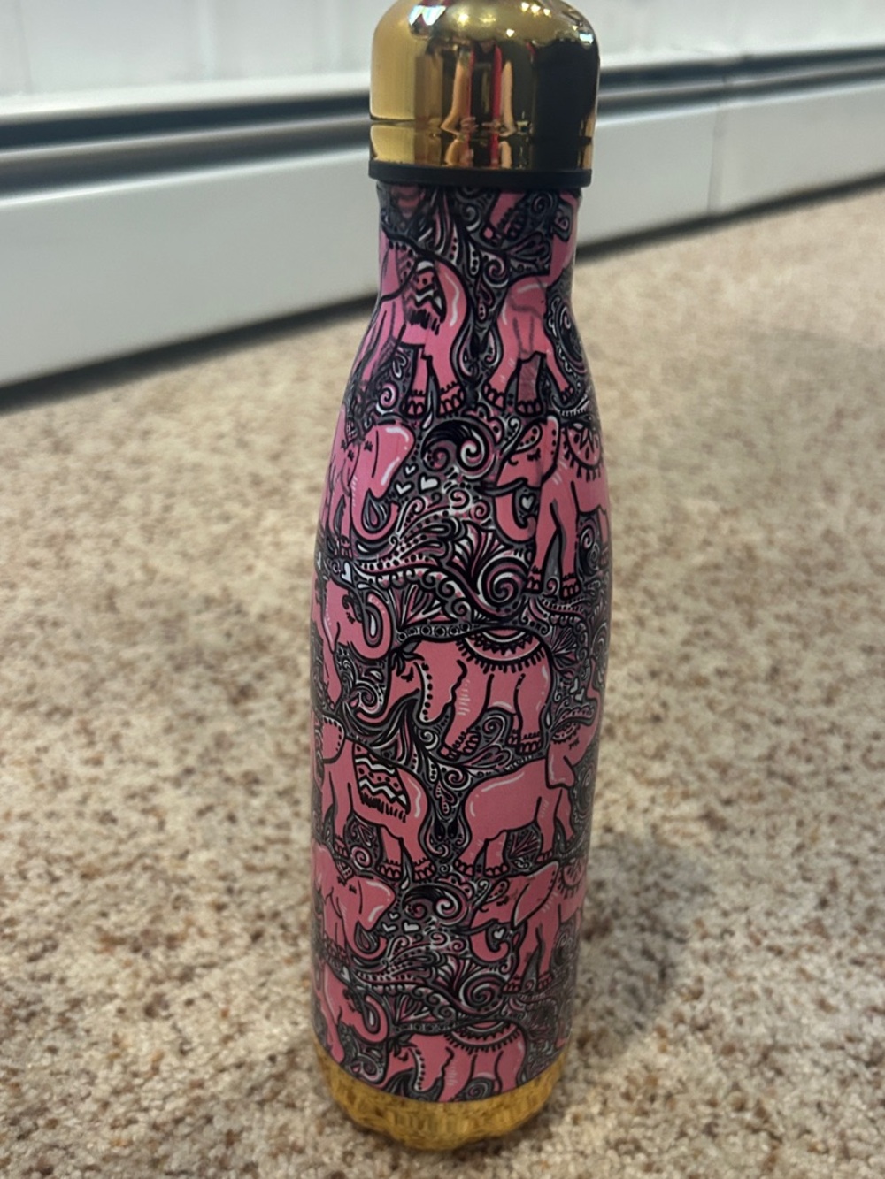 Pink elephant water bottle with gold trim.